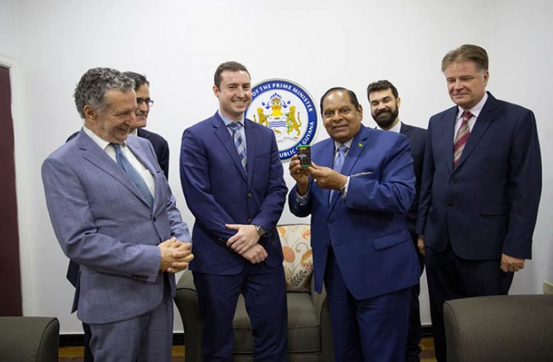 Prime Minister Moses Nagamootoo displays a token from officials of PETROBRAS