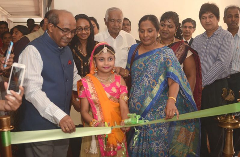 Indian High Commissioner to Guyana, V. Mahalingam, along with other officials of the Indian High Commission in Guyana, watches on as this young girl cuts the ribbon declaring ‘Namaste India’ open Sunday.