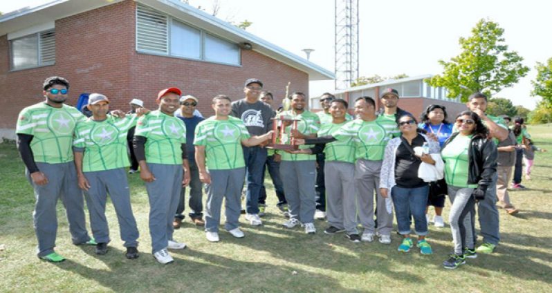 Caribbean Sensation players and supporters pose with the winning trophy. OSCL president Albert Ramcharran (in black) is at centre.
