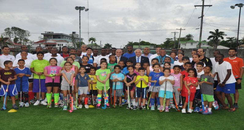 International Hockey Federation (FIH) president Leandro Negre (with black suit and blue tie) strikes a pose with young local hockey players at the GCC ground yesterday. At Negre’s right is Pan American Hockey Federation president Alberto `Coco’ Budeisky).