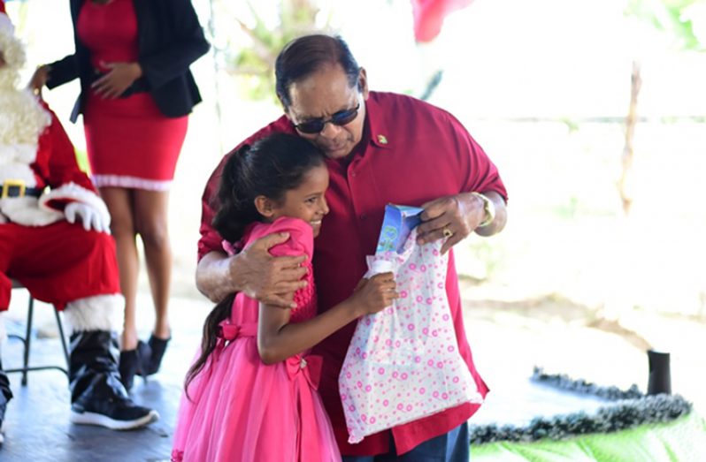 Prime Minister Moses Nagamootoo presents a gift to the beautiful young lady (DPI photo)