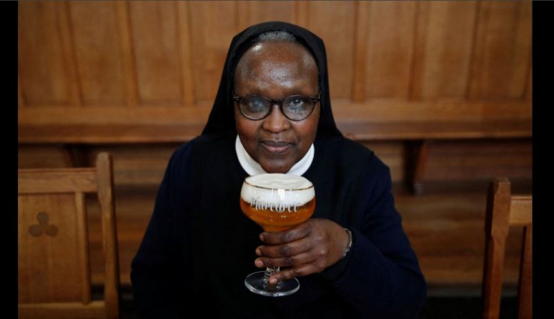 Benedictine Sister Gertrude drinks a "Maredret" beer during an interview with Reuters at the Maredret Abbey, which signed a partnership with the Anthony Martin brewing group to produce two beers labeled "Maredret", with ingredients inspired by the monastery garden, in Anhee, Belgium, December 8, 2021. Picture taken December 8, 2021. REUTERS/Johanna Geron