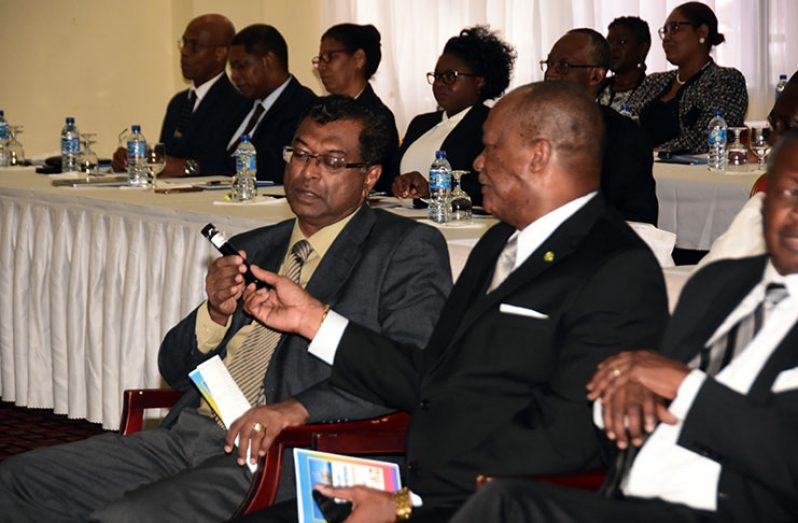 Acting Prime Minister Khemraj Ramjattan and Minister of State, Joseph Harmon examine a sample of Guyana’s crude oil 
Trotman: Minister of Natural Resources, Raphael Trotman, holds up a sample of Guyana’s crude oil(not in photo) during the presentation on Friday (Adrian Narine photo)