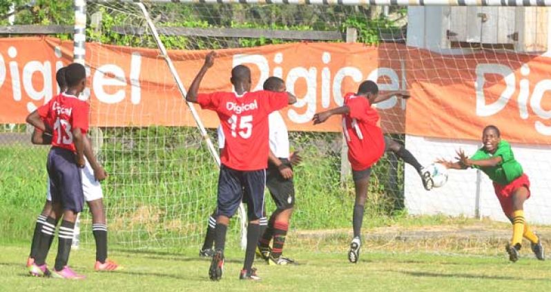The opening goal of the contest between St. Winefride’s and GITC is scored by Stephon Reynolds (#11 red) who beats GITC custodian Azariel Davis (green top) with the well-placed shot, as is captured by Chronicle Sport’s Adrian Narine.