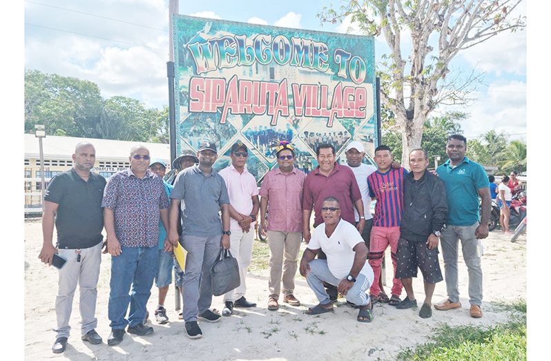 Senior Minister within the Office of the President with Responsibility for Finance, Dr. Ashni Singh and members of his team share a moment with residents of Siparuta