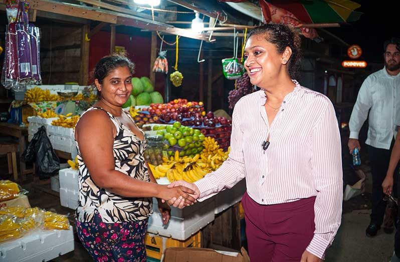 Minister of Local Government and Regional Development, Priya Manickchand (right), interacts with vendors as they were moving into the market