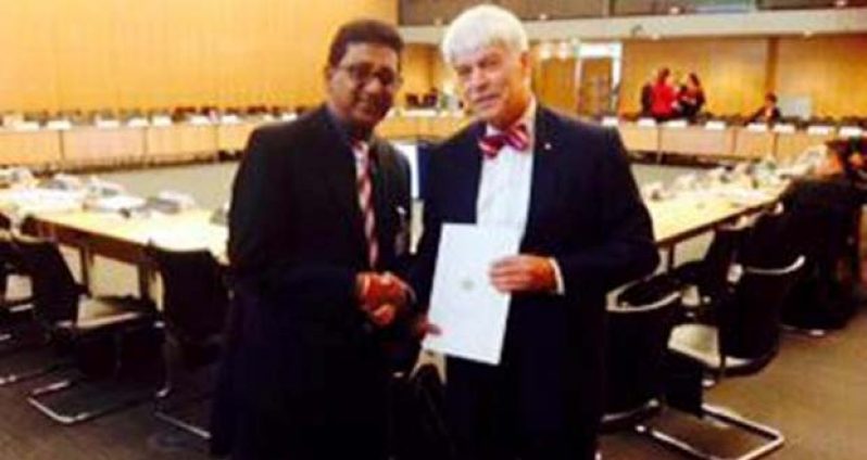 Minister of Legal Affairs and Attorney General, Anil Nandlall hands over the letter of commitment from President Donald Ramotar to President of the Financial Action Task Force, Roger Wilkins AO, in Paris
