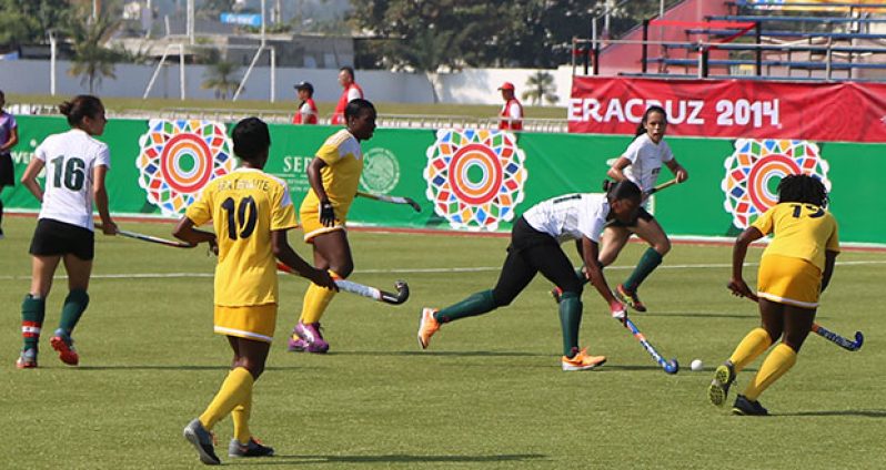 Part of the action between Guyana (white tops) and Barbados on Sunday last during their fifth place play offs in the 2014 Central American and Caribbean Women’s hockey tournament