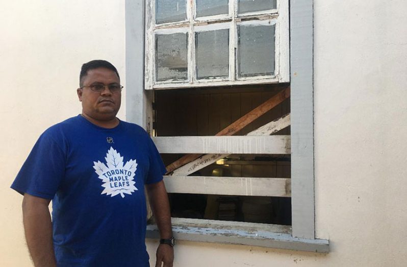 Pastor Kalyan Etwaru stands next to the window the bandits used to gain entry into his house