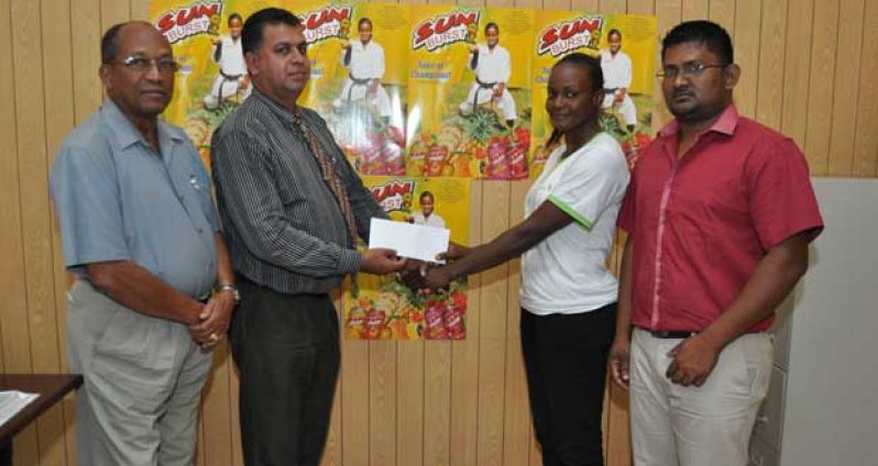 Office Manager, continental Group of Companies, Mr Ravi Brignandan hands over the cheque to Ms Nathalie Gibson in the presence of Mr Percival Boyce (left) and Khemraj Dhanraj..