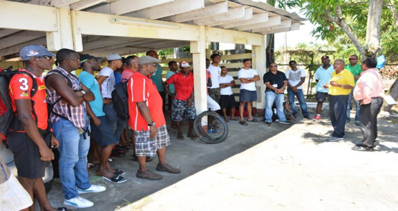 NSC chairman Ivan Persaud addresses the cyclists before their departure for Berbice yesterday. Next to him is race organiser Hassan Mohamed. (Samuel Maughn photo)