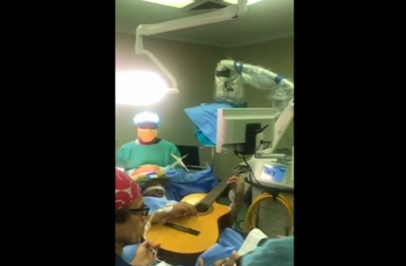Manzini playing his guitar as doctors operated on him. They opted to keep him awake for a reason.