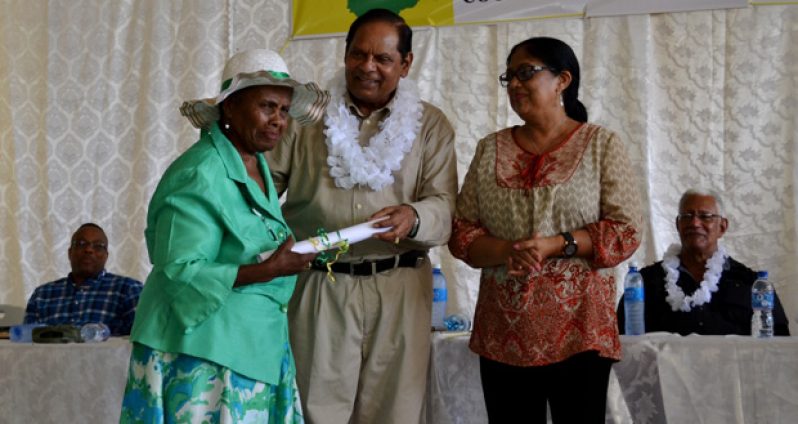 An elderly resident of the Cinderella County receives an award from Prime Minister Nagamootoo