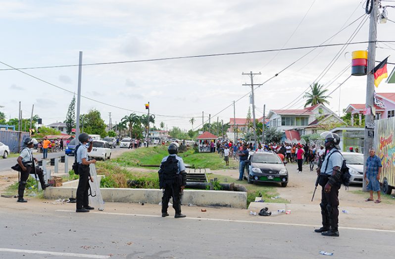 The police at the scene of protests by the PPP/C supporters  on Friday.