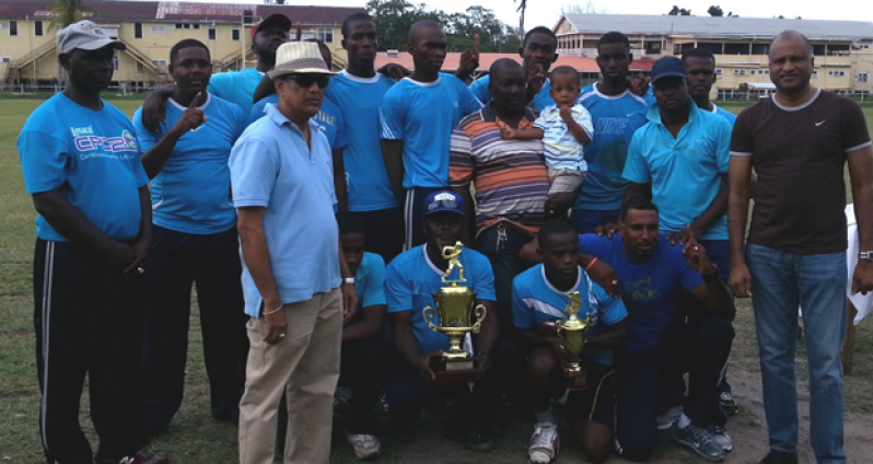 Commissioner of Police (ag) Seelall Persaud (right) and exclusive sponsor of this T20 tournament Cobeer Persaud, Managing Director of C. Persaud Dental Services (left with shades), pose with the victorious Tactical Services Unit (TSU) team yesterday.
