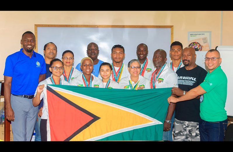 Director of Sport, Christopher Jones, poses with the posse of powerlifters that represented Guyana at the NAPF and FESUPO Championships in Orlando, Florida recently.
