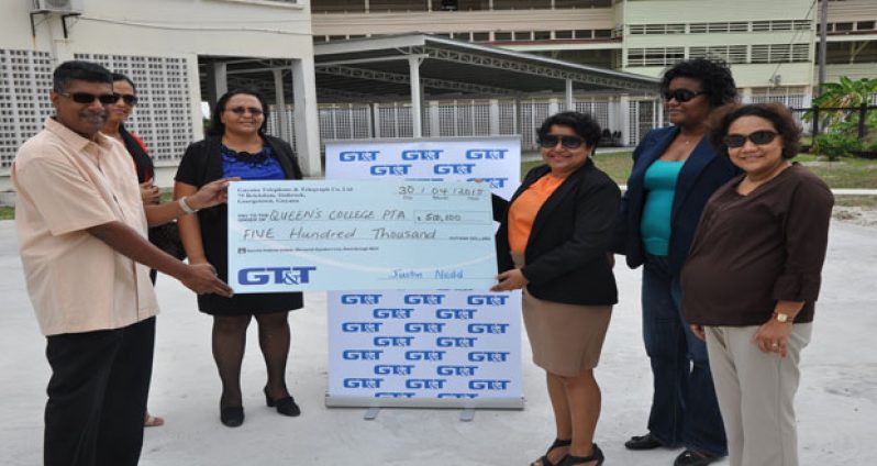 Queen’s College Parent-Teacher Association president Neil Persram (extreme left) accepts the symbolic cheque from GT&T’s senior marketing manager Nadia DeAbreu (third right) while the PTA secretary Marcelle Shewjattan (partly hidden), Head Mistress Jackie Benn-Ralph (third left) and GT&T’s Public Relations Officer Allison Parker (right) look on.