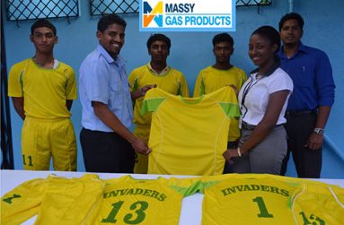 Invaders Captain Vaickesh Dhaniram receives the uniforms from Massy Gas Products Customer Services Officer Elicia Chapman while some members of the team look on.