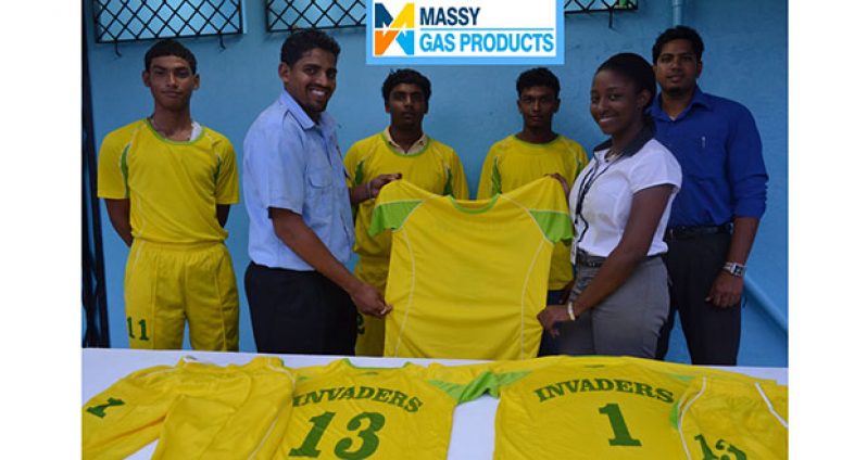 Invaders Captain Vaickesh Dhaniram receives the uniforms from Massy Gas Products Customer Services Officer Elicia Chapman while some members of the team look on.