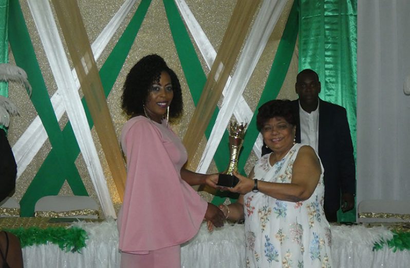 Minister of Social Protection Amna Ally presents an award to a Linden woman on Sunday