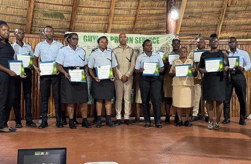 Director of Prisons Nicklon Elliot (centre), flanked by prison officers who graduated from the training courses