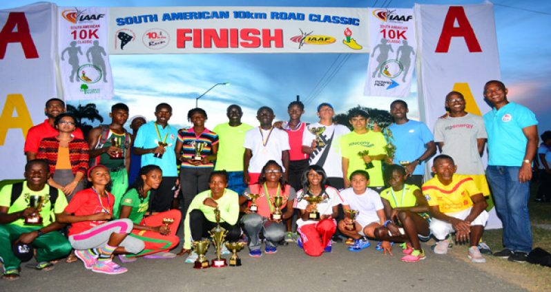 Prize winners of the various categories of the South American 10K Road Race strike a pose with their winning trophies (Photo by Samuel Maughn).