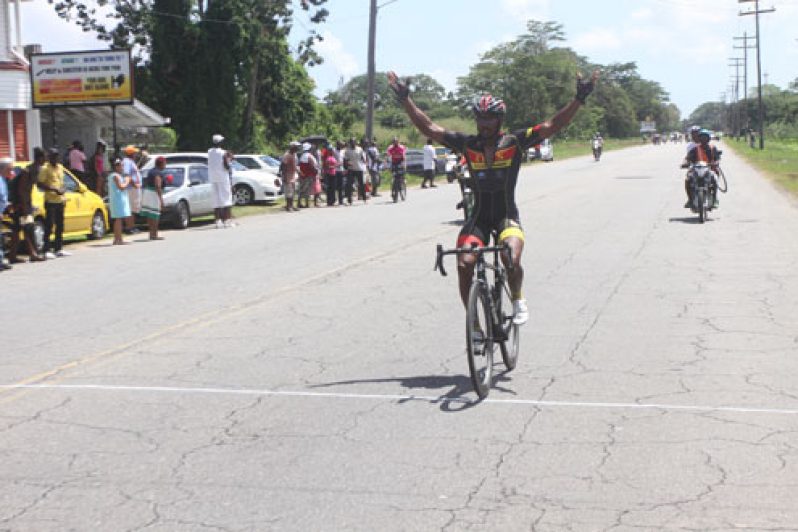 Robin Persaud raises his hands in the air as he crosses the finish line yesterday, knowing very well that he had won the NSC/NAPS’s 8th annual `Ride for Life’ five-stage cycle road race, after outsprinting his more illustrious opponents.