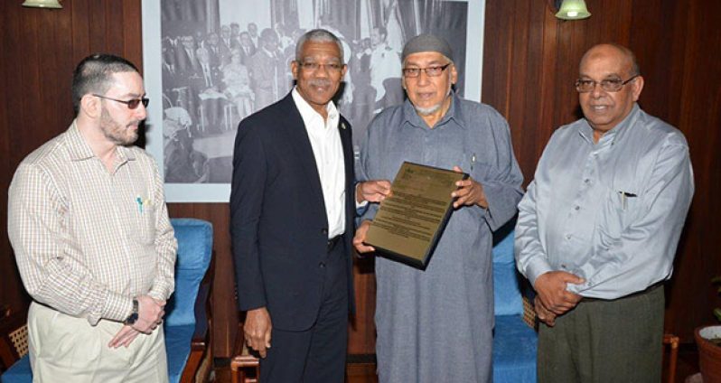 President David Granger receives the plaque from President of the CIOG, Al Hajj Fazeel M. Ferouz, while Sheik Moen ul-Hack (left) and Mr. Khakan Ramjohn look on