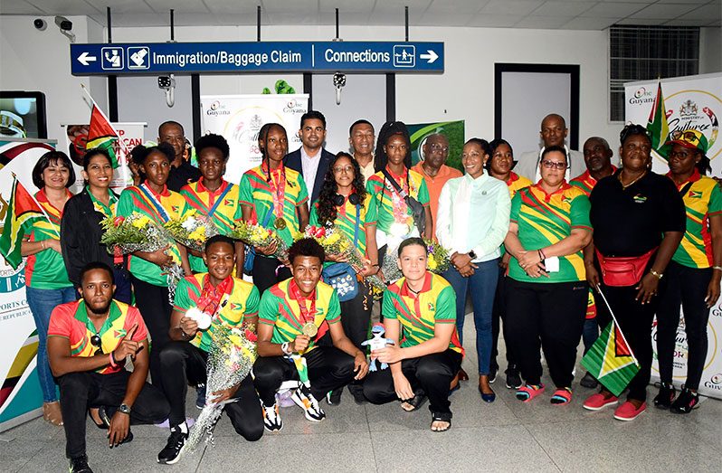 Minister Charles Ramson and other officials take a photo-op with Team Guyana. (Adrian Narine photo)