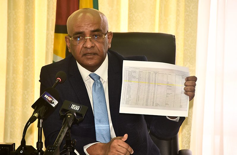 Vice-President Dr Bharrat Jagdeo shows members of the media the document which lists the building as one that belongs to the state (Adrian Narine photo)