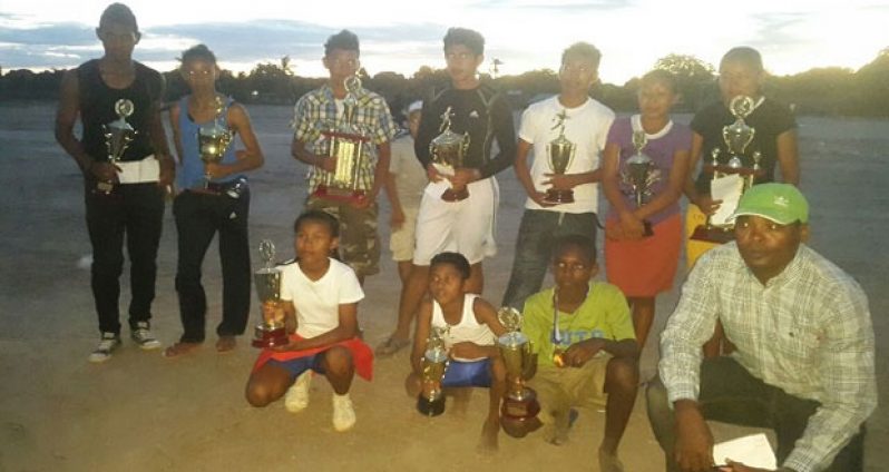 REGION 9 WINNERS - Age group winners in Region 9 pose with their trophies and Upper Takatu/Upper Essequibo representative Kenrick Lewis.