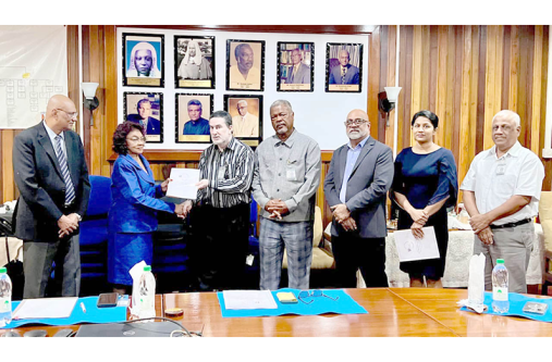 ERC's Chair Shaikh Moeen-ul-Hack hands over the Election Observer Report 2025 to GECOM Chairperson Justice (Ret’d) Claudette Singh. Also pictured are the Chief Election Officer Vishnu Persaud (left) and several ERC officials