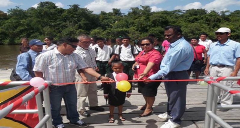 A child cuts the ribbon to commission the new stelling at St. Monica in the Pomeroon