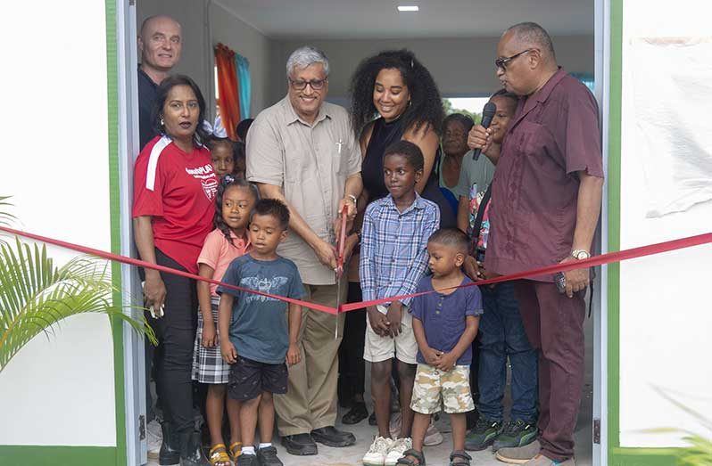 DDL Chairman/CEO, Komal Samaroo flanked by invitees and locals in the ribbon-cutting exercise, signalling the opening of the Moblissa Community Centre (Japheth Savory photo)