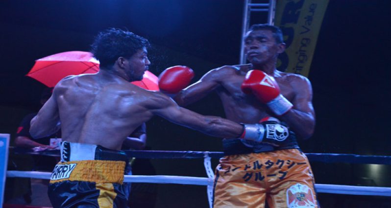 Elton `The Bully’ Dharry (left) connects with a right dig to the body of Felif Machado during their 10-round bantamweight fight at the Giftland Mall on Saturday night.