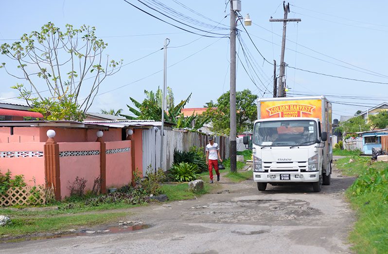 A canter truck maneuvering brick-filled potholes in West Ruimveldt