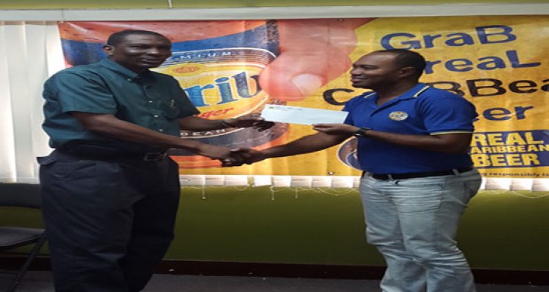 Carib Beer Brand Manager Nigel Worrell (right) hands over the sponsorship cheque to GCA President Roger Harper.