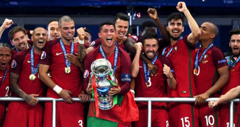 Cristiano Ronaldo (C) of Portugal of lifts the Henri Delaunay trophy at the end of their UEFA EURO 2016 final match against France