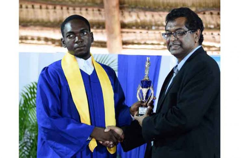 Second runner-up Ezekiel Roache receiving his trophy from Minister of Public Security, Khemraj Ramjattan