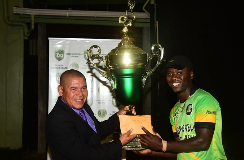 Minister of Social Cohesion/Sport, Dr George Norton, hands over the spoils to captain of the Rutherford Renegades, Sherfane Rutherford.
