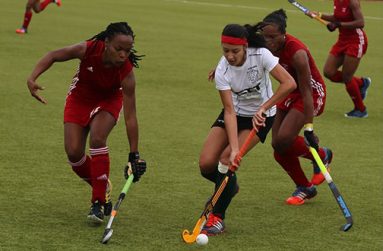 Samantha Fernandes surrounded by Trinidadian defenders in red.