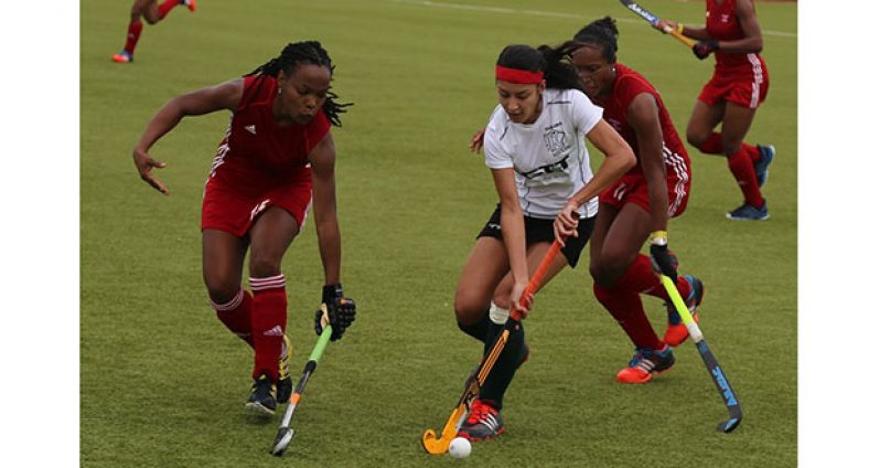 Samantha Fernandes surrounded by Trinidadian defenders in red.