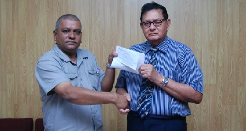 Justice Cecil Kennard (right) accepts the sponsorship cheque from Berbice River Bridge Company Inc. Chief Executive Officer Amadat Samaroo (photo by Cullen Bess-Nelson)