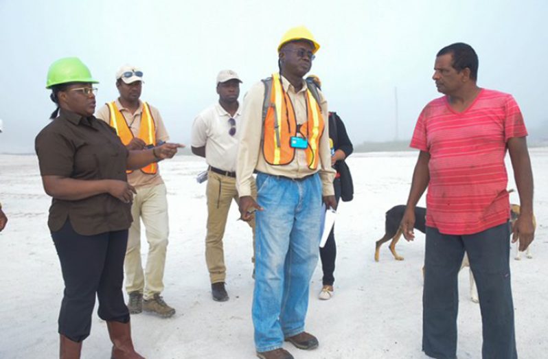 Minister within the Ministry of Natural Resources, Simona Broomes, and GGMC staff in discussion with a sandpit operator from Dora Park