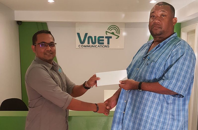 Hilbert Foster receives sponsorship cheque from V-Net CEO Safraz Sheriffudeen.