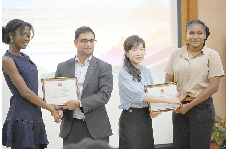 Minister of Public Service, Government Efficiency, and Implementation, Zulfikar Ally and Chinese Ambassador to Guyana, Yang Yang, present the scholarship awards to the 2026 recipients Ronetta Taquasha Cort and Sasha Latanya Bentham (Sachin Persaud photo)
