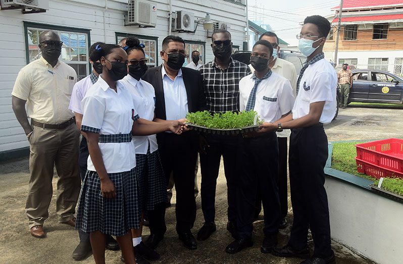Agriculture Minister, Zulfikar Mustapha, handing over planting materials to a few students of the North Georgetown Secondary School’s Agriculture Department (Adrian Narine photo)