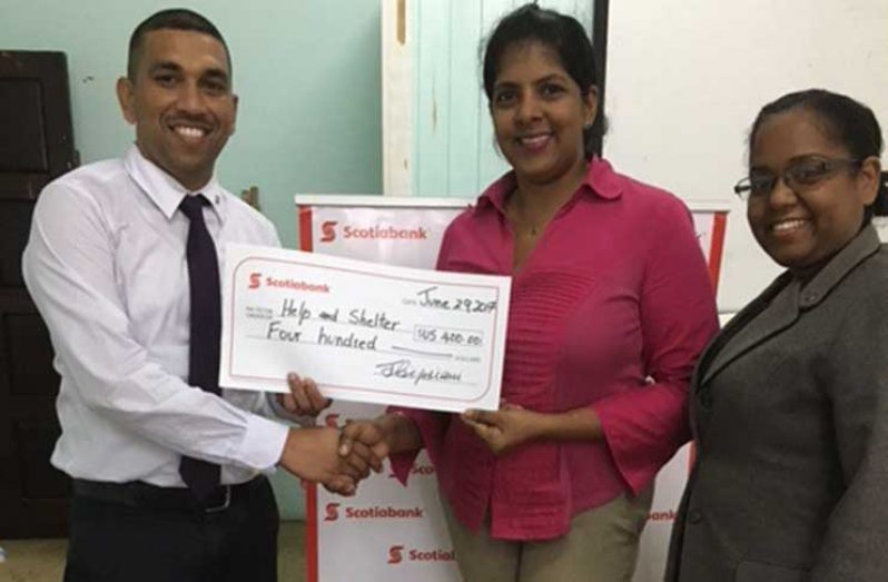 Help and Shelter Director, Niveta Shivjatan, accepts the donation from proud Scotiabankers: Andy Budhu and Natalie Noel