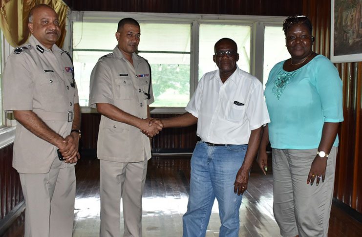 ‘E’ Division Commander Fazil Karimbaksh and Region 10  Chairman Renis Morian shake hands as Police Commissioner Seelall Persaud (left) and Community Development Council (CDC) Deputy National Director Sandra Adams look on