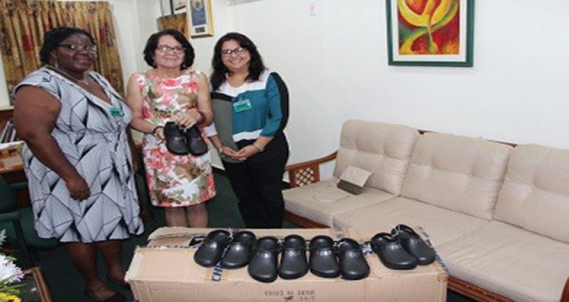 First Lady Sandra Granger smiles as she displays a pair of shoes donated by the Rotary Club of Stabroek to ‘the shoes that grow project’, operated under the auspices of her office. She is flanked by, from left, the Club’s Assistant Secretary Grace McCalman and Past President Luana Falconer, on her right